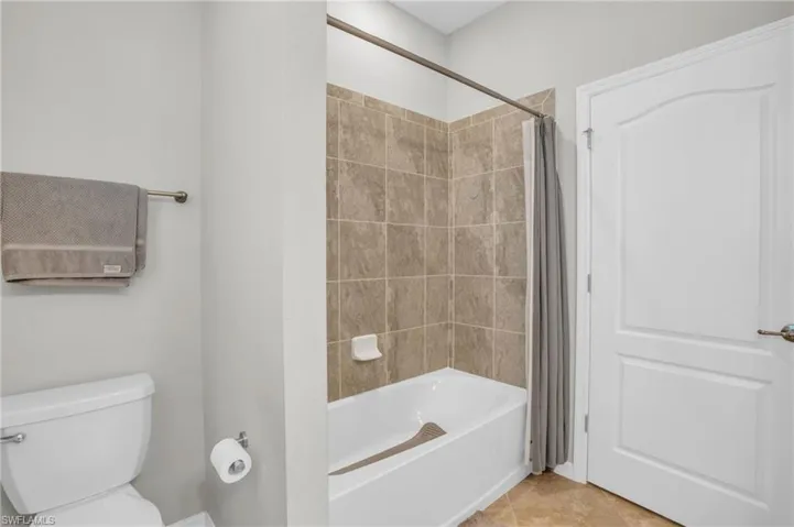 Full bath featuring shower / tub combo and light tile patterned floors
