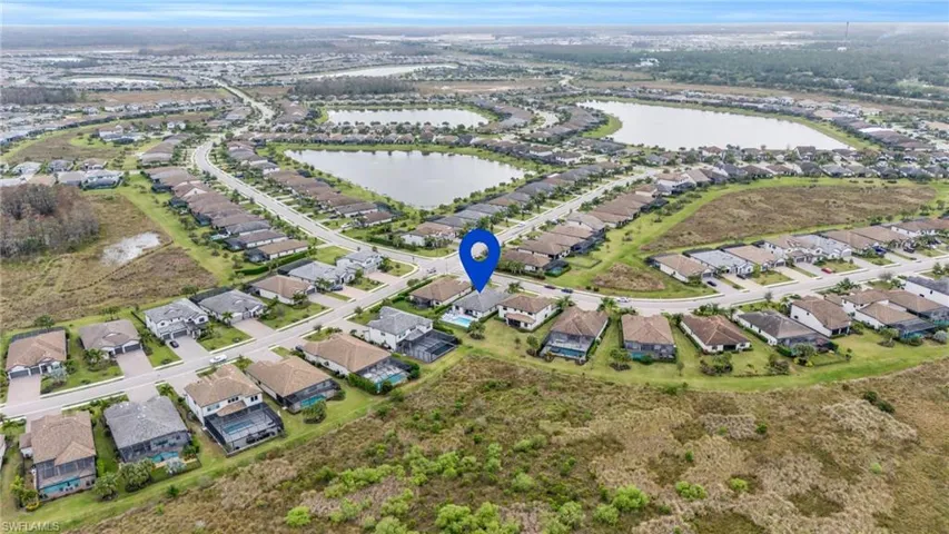 Aerial view of property and surrounding area with nearby suburban area and a large body of water