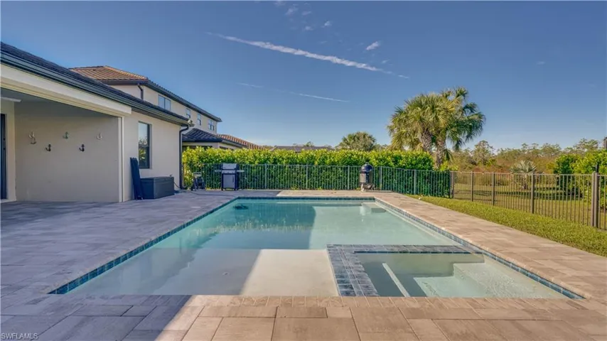 View of swimming pool with a fenced backyard, a patio, and a pool with connected hot tub