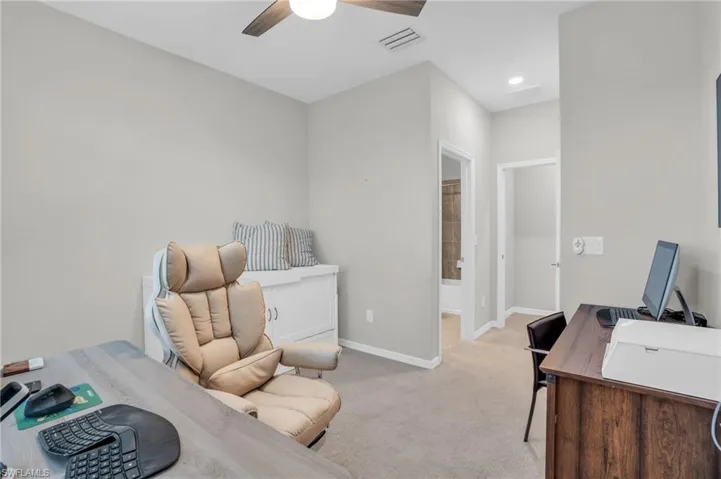 Bedroom with an office area, light colored carpet, ensuite bath, a ceiling fan, and recessed lighting