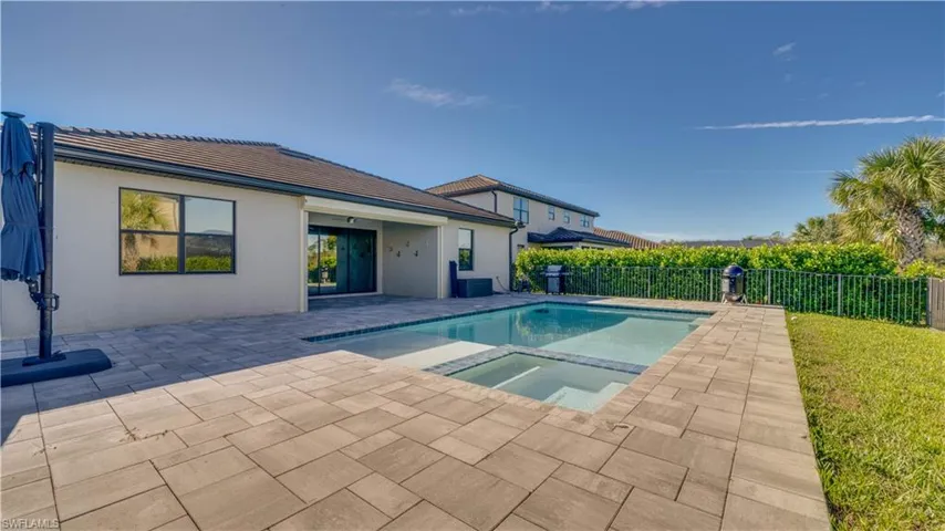 View of pool with a patio area, a pool with connected hot tub, and a fenced backyard