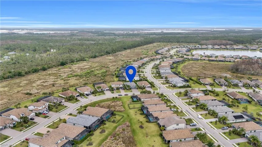 Aerial view of property and surrounding area with nearby suburban area and a nearby body of water