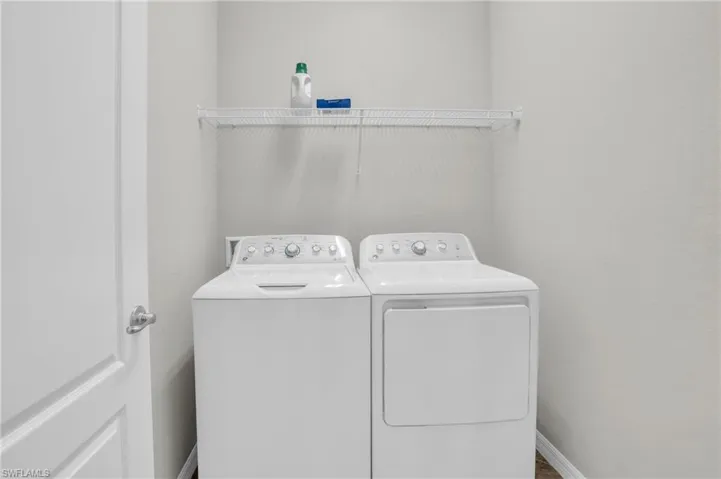 Washroom featuring washer and dryer and baseboards
