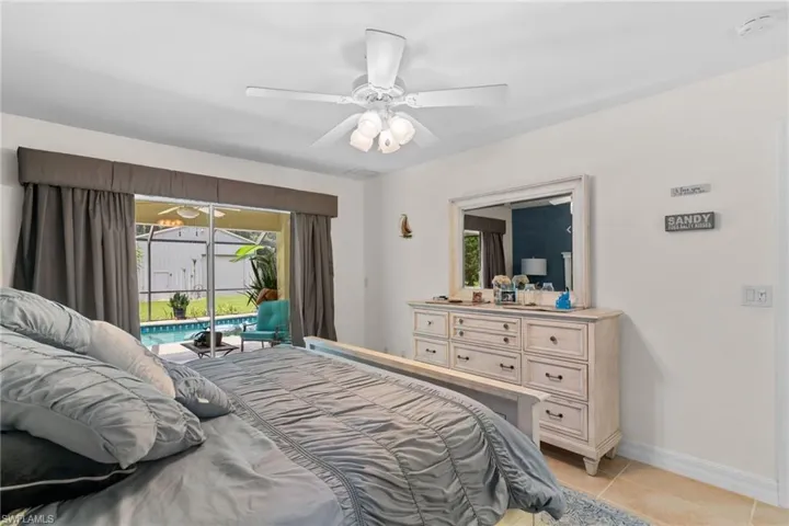 Bedroom with sliding glass doors opening to an outdoor pool area