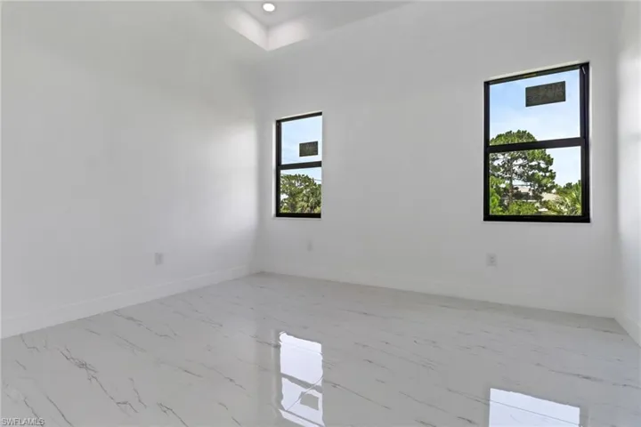 Spare room with light marble finish flooring and baseboards