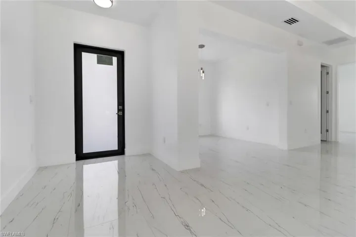Spare room with baseboards and light marble finish floors