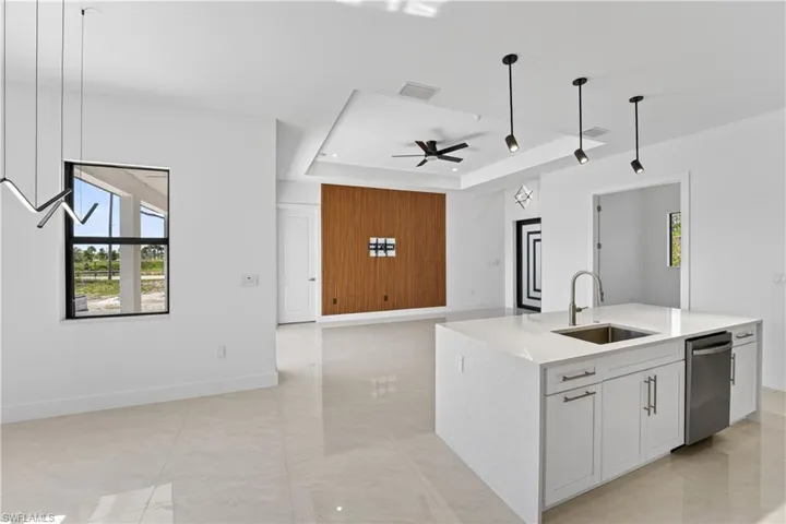 Kitchen island featuring a stainless steel sink, gooseneck faucet, and integrated dishwasher