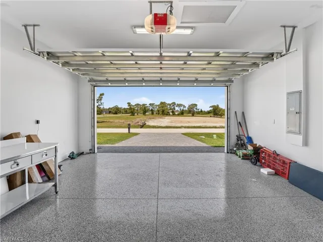 Garage featuring a speckled epoxy floor, white walls, and an overhead garage door opener