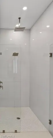 Walk-in shower featuring a ceiling-mounted rainfall showerhead and a wall-mounted square showerhead