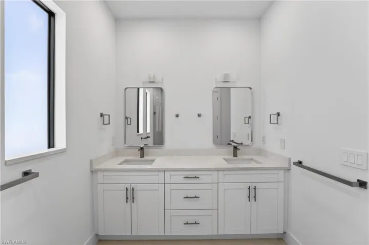 Dual vanity with light-toned countertop, integrated sinks, and matte black faucets