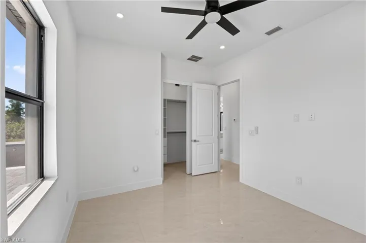 Room featuring light-toned tile flooring, a black ceiling fan, and recessed lighting