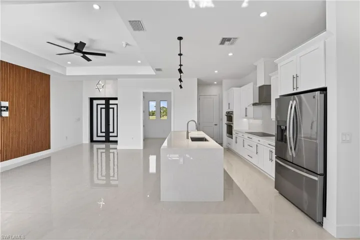Open-concept living space with large format tile flooring and a modern kitchen