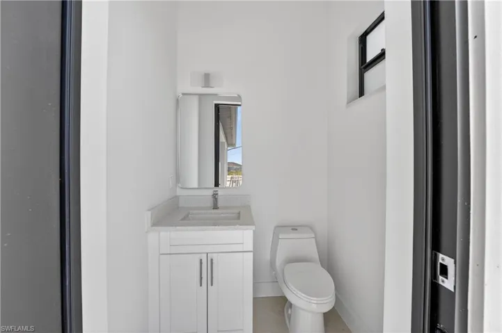 Bathroom featuring a white vanity with a light-colored countertop, an undermount sink, and a rectangular mirror