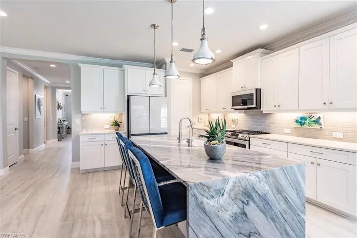Three counter stools at the island stay with the home