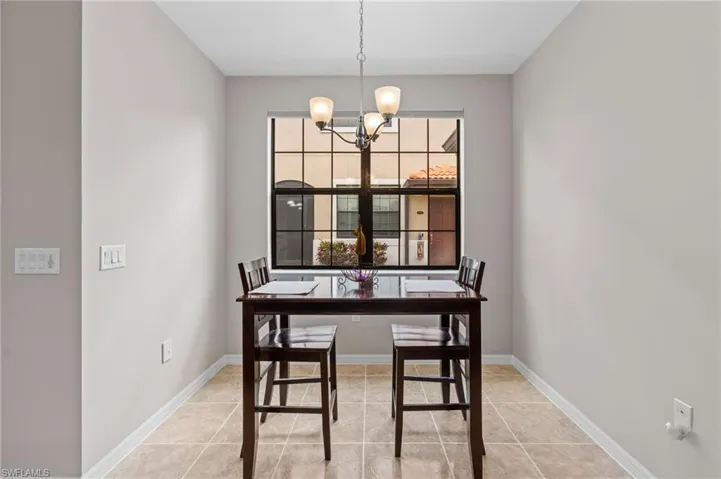 Dining room featuring baseboards, a notable chandelier, and light tile patterned floors
