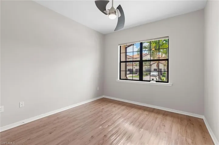 Empty room with light wood finished floors, a ceiling fan, and baseboards
