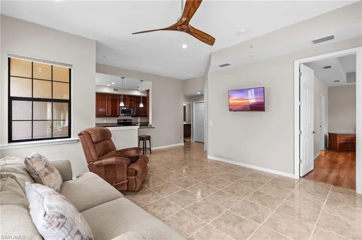 Living room featuring light tile patterned flooring, visible vents, a ceiling fan, and recessed lighting