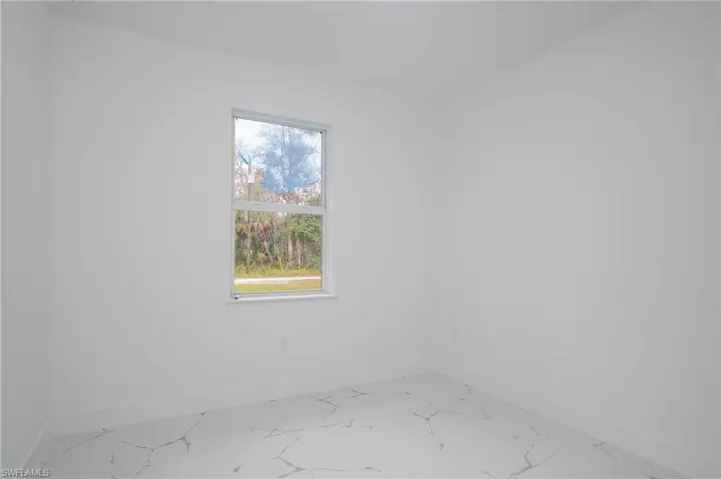 Spare room with baseboards and light marble finish flooring