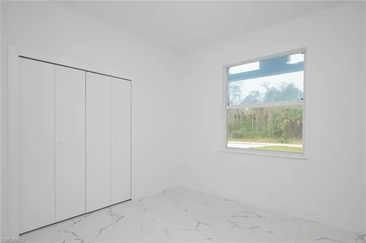 Unfurnished bedroom with a closet and marble look tiles