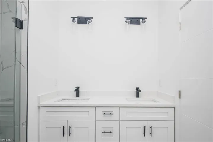 Bathroom with double vanity and a stall shower