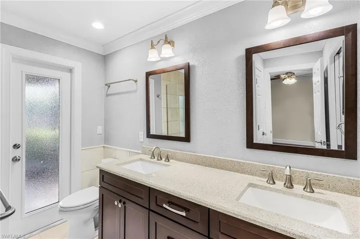 Dual vanity with wood-finish cabinetry and light-toned countertops