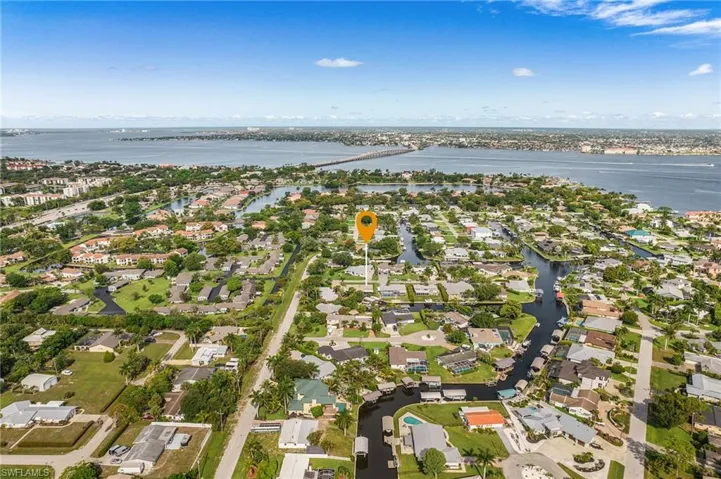 Aerial perspective showcasing a residential area with canal access, multiple homes, and surrounding waterways
