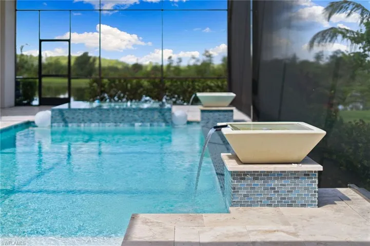 View of swimming pool with pool water feature and lake views