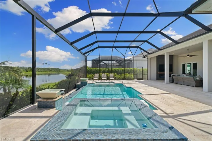 View of infinity edge pool with an oversized lanai area, ceiling fan, an in ground hot tub, a water view, and screen enclosure