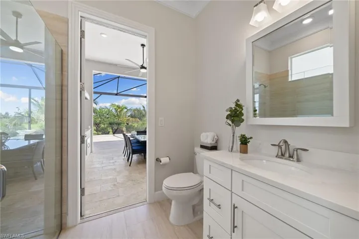 Bathroom functioning as cabana bath featuring vanity, toilet, plank tile and a wealth of natural light