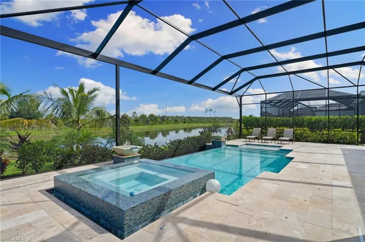 View of infinity edge swimming pool with an in ground hot tub, extended lanai and water view