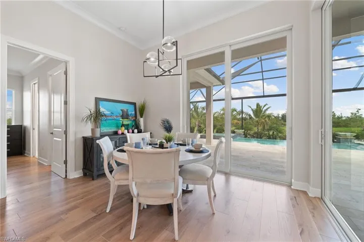 Dining room featuring hardwood flooring, crown molding, and a chandelier