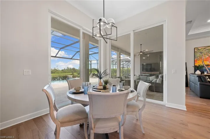 Dining area featuring ceiling fan with notable chandelier and light hardwood floors