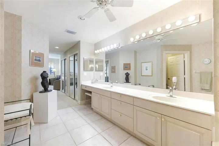 Full bathroom with double vanity, a ceiling fan, wallpapered walls, and light tile patterned flooring