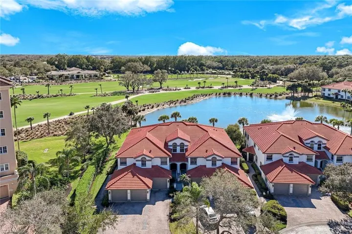 Aerial perspective of suburban area featuring a nearby body of water and a golf course