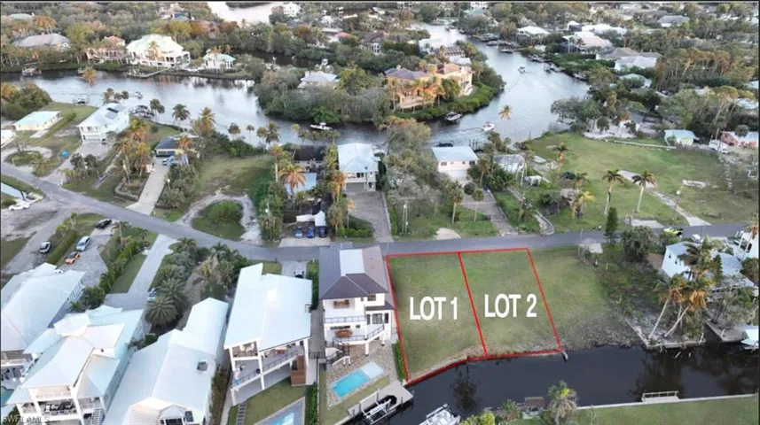 Aerial view of residential area with a nearby body of water and property parcel outlined