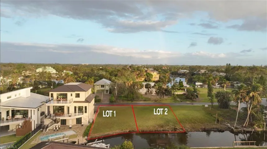 Aerial view of residential area with a large body of water and property parcel outlined