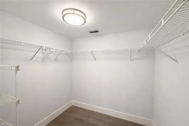 Walk in closet featuring dark wood-type flooring