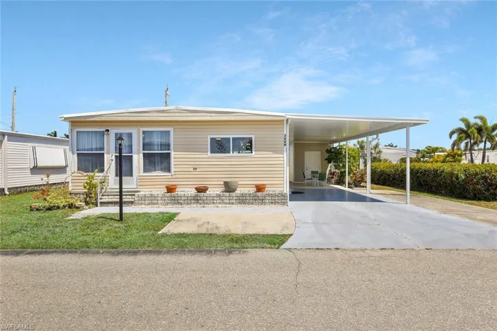 Manufactured / mobile home featuring a carport, driveway, and entry steps