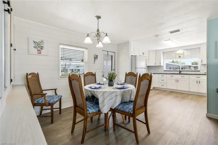 Dining room with a chandelier, a healthy amount of sunlight, and light wood finished floors