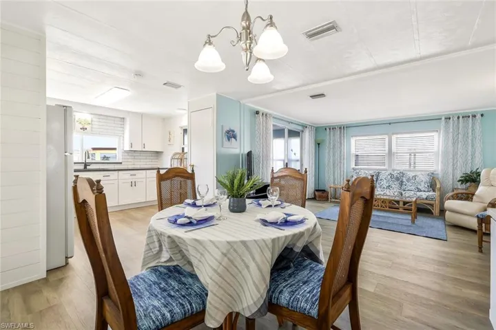 Dining area with a notable chandelier, visible vents, and light wood-style flooring