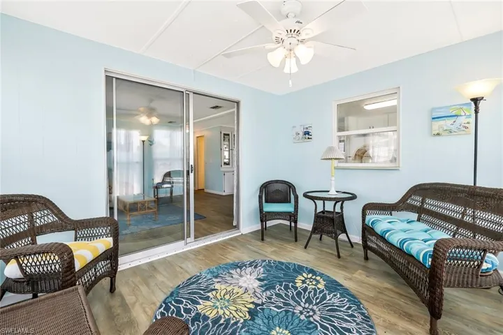 Living area with baseboards, a ceiling fan, and wood finished floors