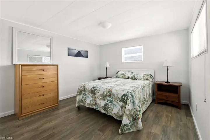 Bedroom with baseboards and dark wood-style floors