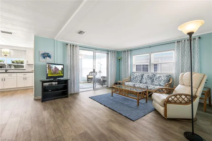 Living room with a wealth of natural light, wood finished floors, and visible vents