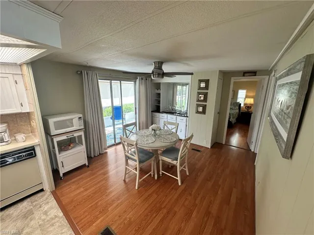 Dining area featuring ceiling fan, sink, a textured ceiling, and hardwood / wood-style flooring