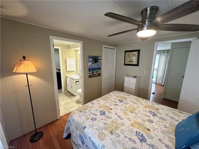 Tiled bedroom with connected bathroom, a closet, sink, and ceiling fan