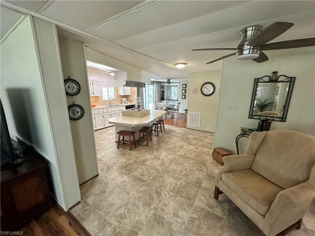 Living room with sink, light wood-type flooring, and ceiling fan