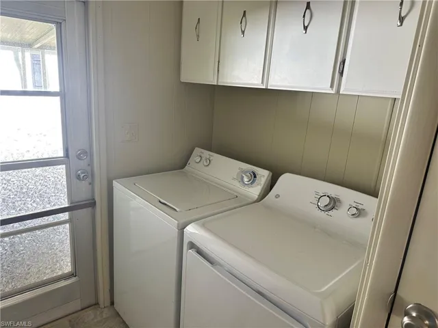 Laundry area featuring separate washer and dryer and cabinets