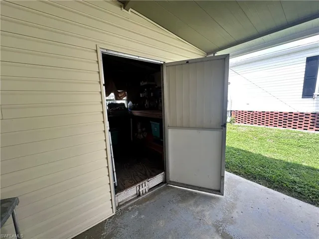 Entrance to property featuring a patio and a lawn