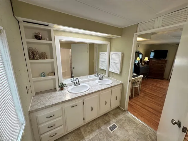 Bathroom with dual vanity and tile patterned flooring
