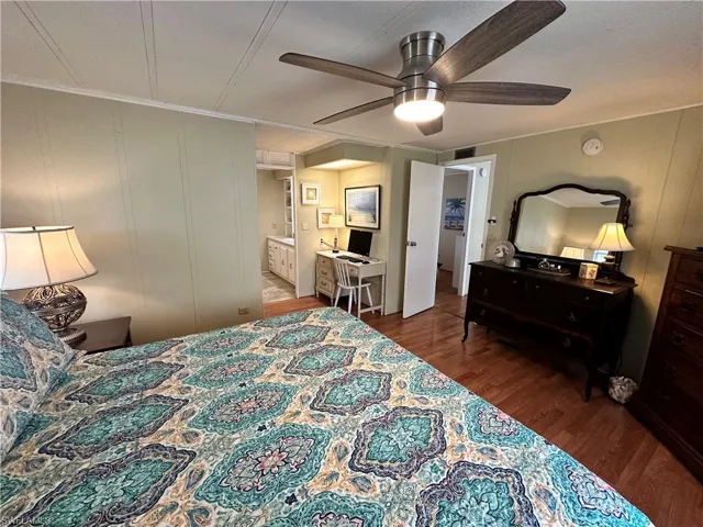 Bedroom featuring ensuite bath, wood-type flooring, and ceiling fan